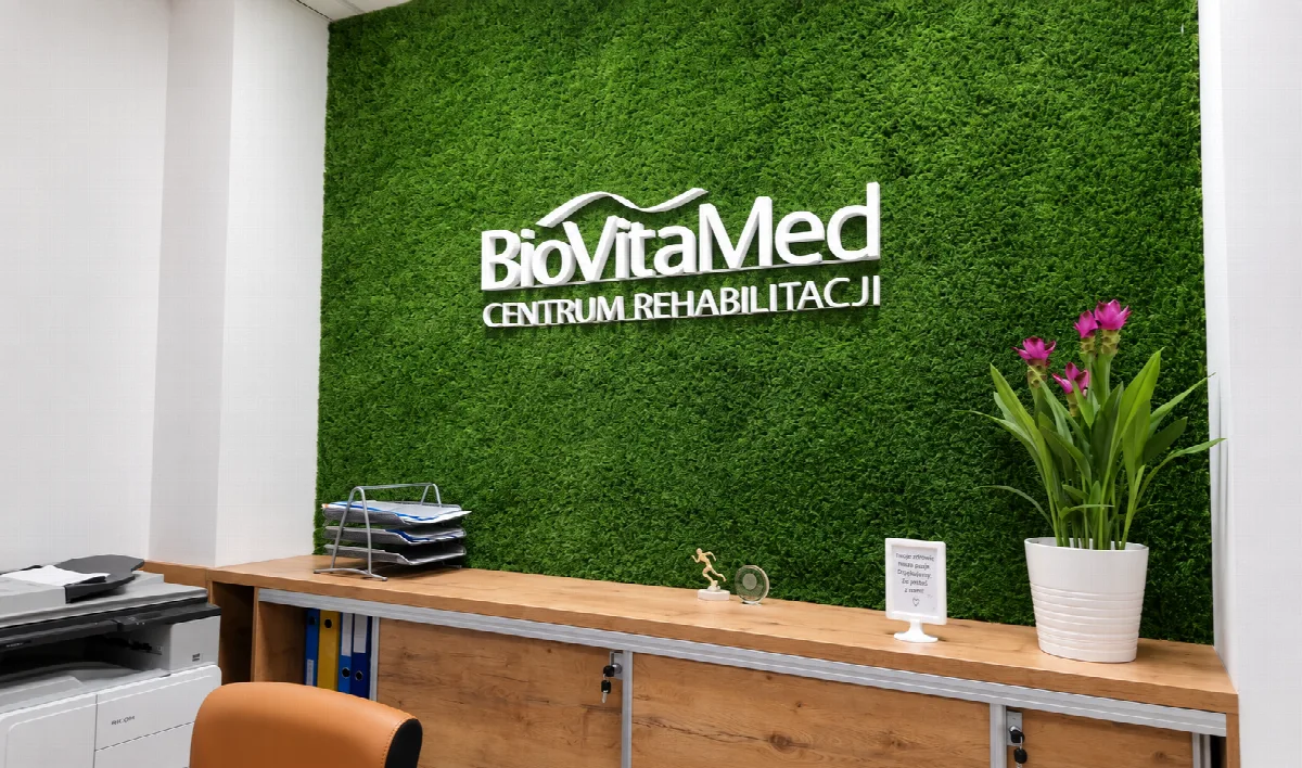 Recepcja BioVitaMed w Tarnowie z zieloną ścianą i logo centrum.